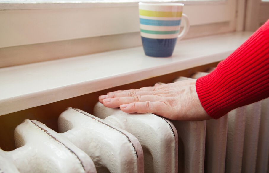 A person's hands on a radiator