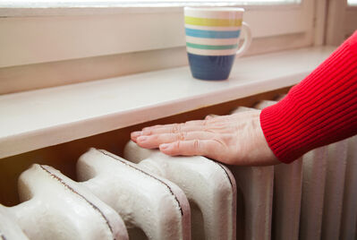 A person's hands on a radiator