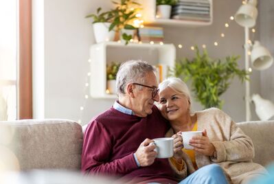 Two older people sitting on a sofa