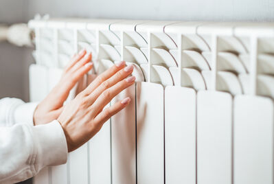 Someone warming their hands on a radiator