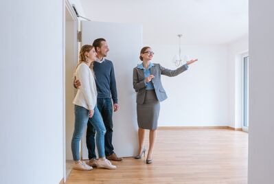 An estate agent showing a couple round a house