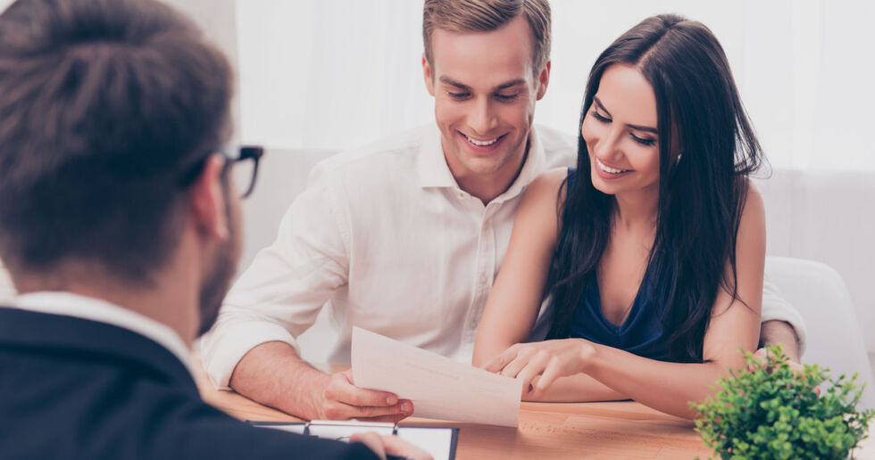 Couple looking through paperwork with estate agent 