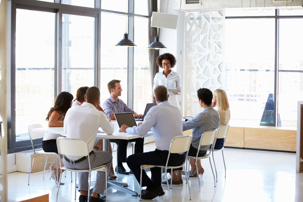 A group of graduates in an office meeting
