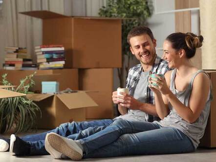 Happy couple on floor surrounded by boxes