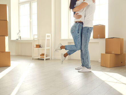 Happy couple hug in a new house.