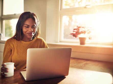 Lady on a computer with a yellow jumper