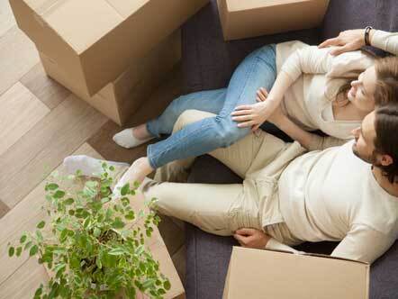Relaxed couple resting on sofa on moving day